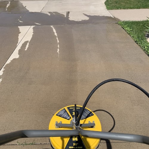 Driveway of residential home with power washer on it